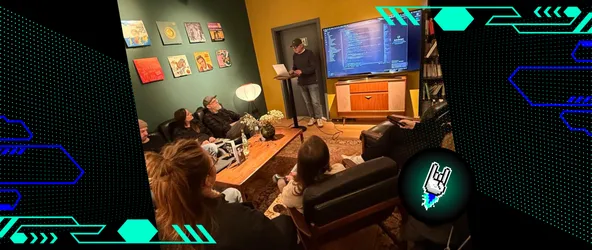 Foto vom AI Meetup im Dezember 2025 in Bochum, bei dem die Gäste nach vorne schauen. Dort hält ein Teilnehmer eine Rede, bei der er auf seinen Laptop guckt. Hinter ihm ist seine Präsentation auf einem Bildschirm zu sehen.